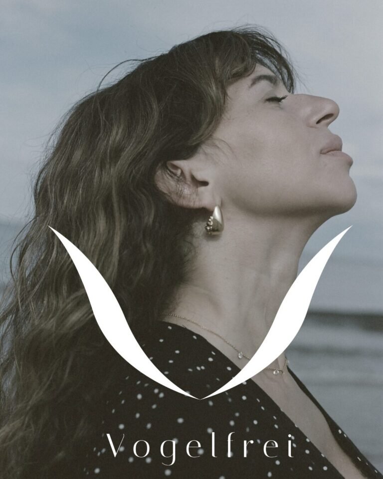 logo juwelier vogelfrei mit frau im hintergrund und meer