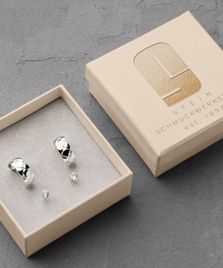 Schmuckschachtel in beige mit goldenem logo stein schmuckwerkstatt mit ringen in silber